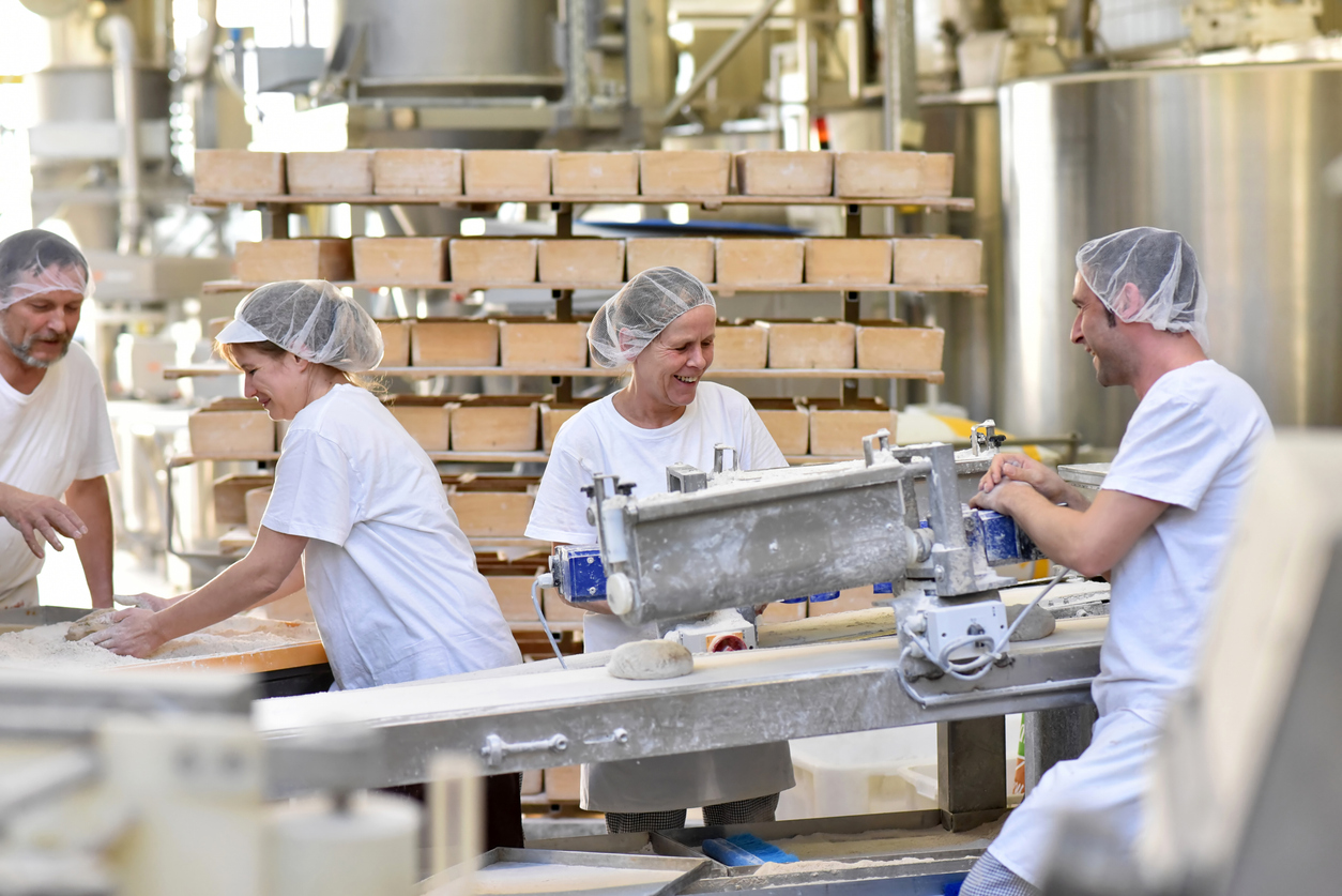 Workers bake bread in an industrial bakery | CMMS