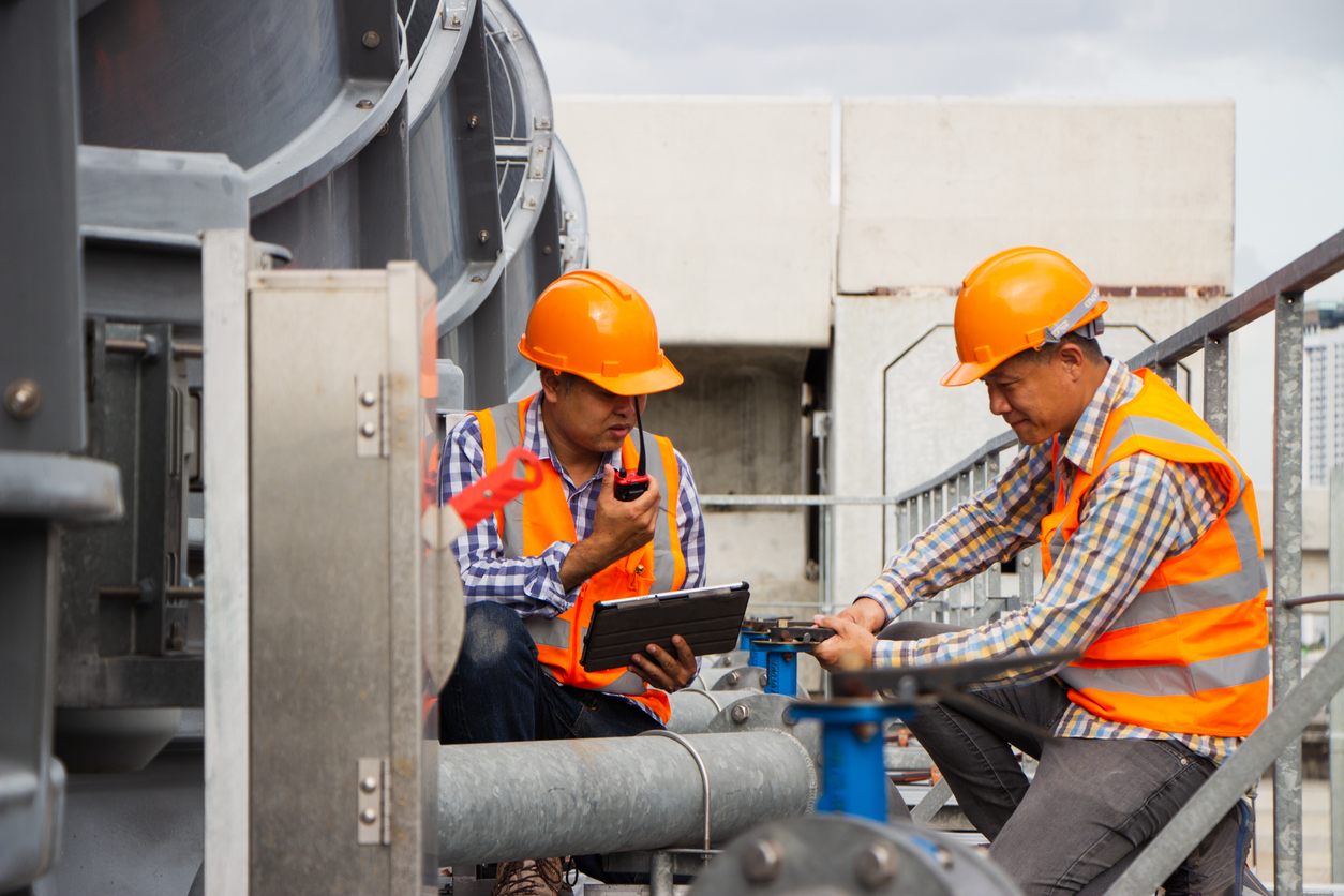 Two maintenance workers perfoming repairs on rooftop | Maintainly