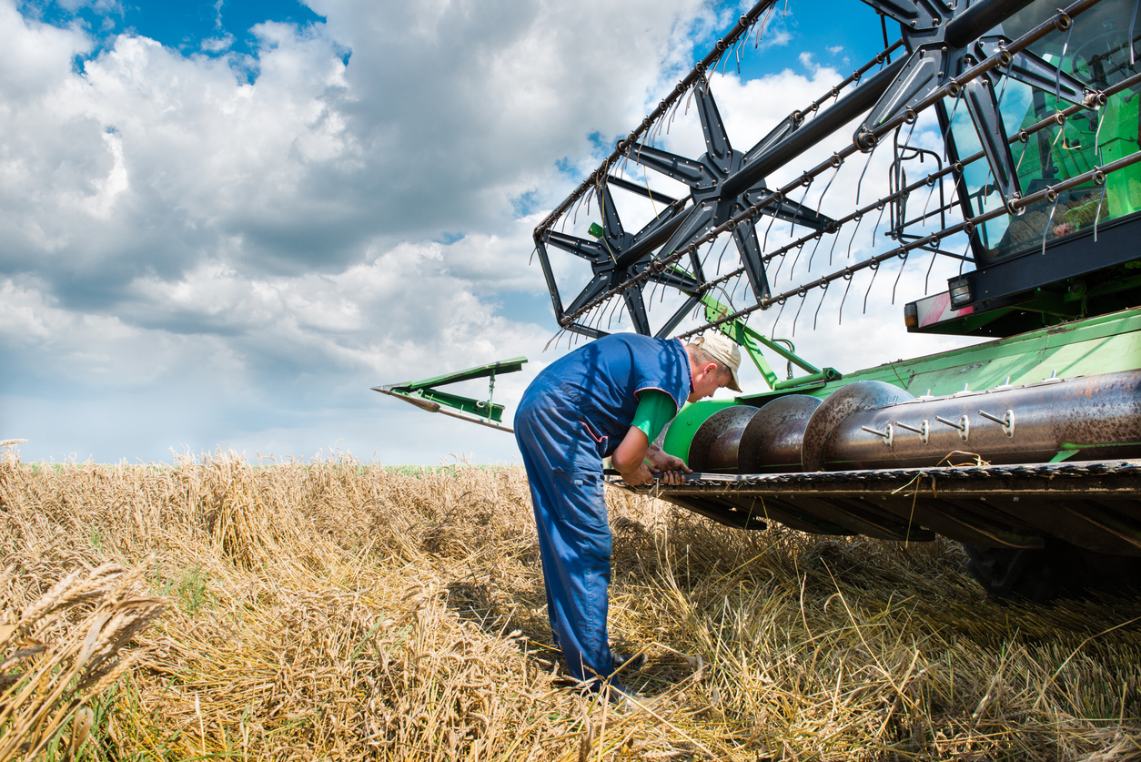 Farmer inspects farming equipment during a breakdown | Maintainly