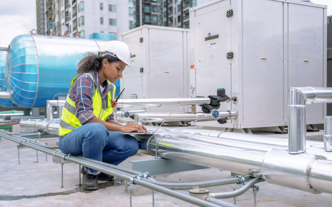 Maintenance worker on roof with laptop | CMMS