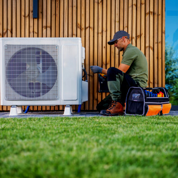 Man performs maintenance on air conditioner | CMMS
