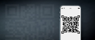 QR code on white mobile phone with large QR hologram in brackground
