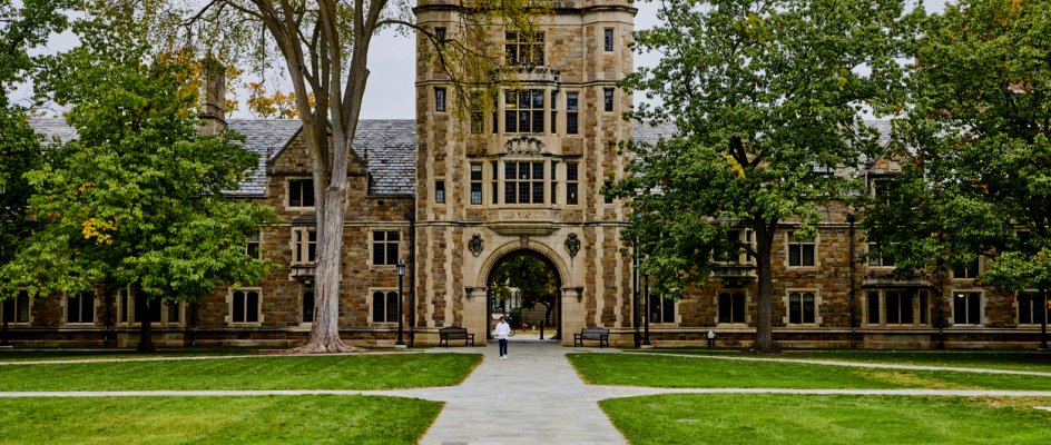 Entrance to a grand old college campus with path leading to building