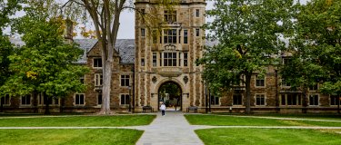 Entrance to a grand old college campus with path leading to building