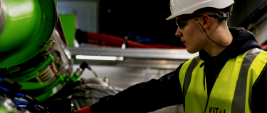 Energy worker attends to heavy industrial equipment asset | CMMS