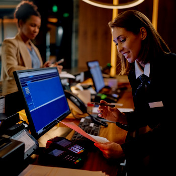 Hotel guest checking in at front desk | CMMS