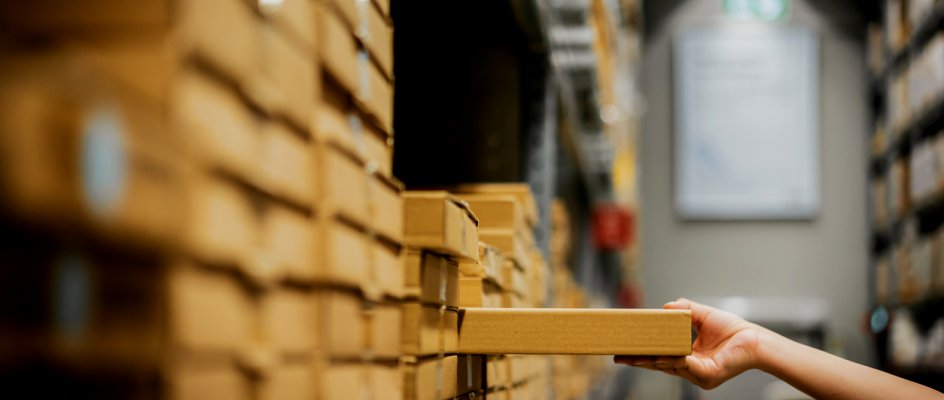 Arm and hand of person reaching out to restock inventory on shelf | CMMS