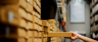 Arm and hand of person reaching out to restock inventory on shelf | CMMS