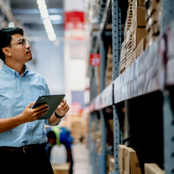 Warehouse staff inspect inventory holding mobile CMMS device