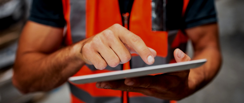 Safety & compliance worker is vest and holding tablet | CMMS