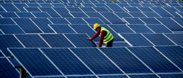 maintenance worker inspection on field of solar panels