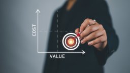 Hand placing a dart in the centre of a target on a chart plotting cost against value
