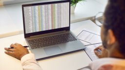 User looks at spreadsheets on a laptop | CMMS