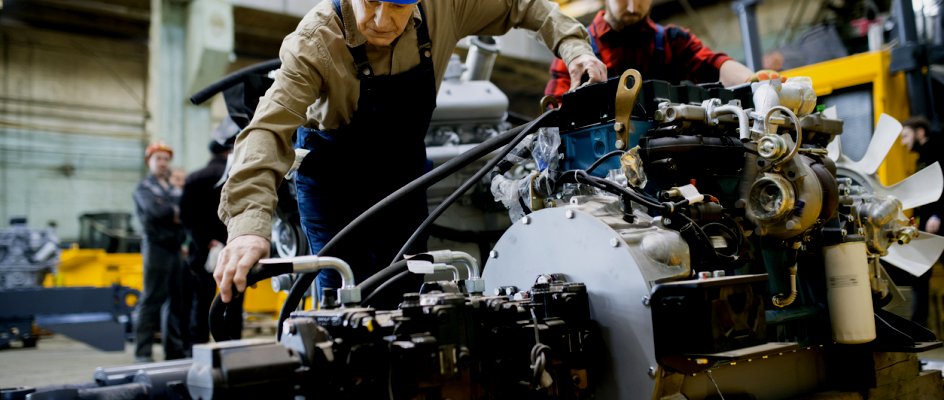 Maintenance technicians in hardhats service an engine | CMMS