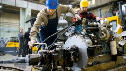 Maintenance technicians in hardhats service an engine | CMMS
