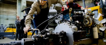 Maintenance technicians in hardhats service an engine | CMMS