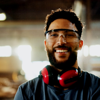 Smiling maintenance worker on the factory floor | CMMS