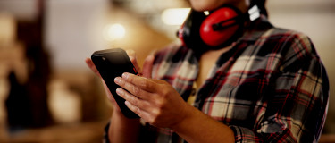 Maintenance worker completes work order on mobile phone CMMS app