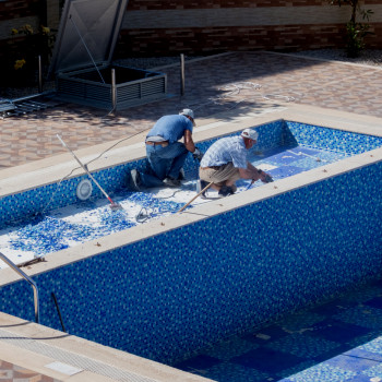 Workers clean a commercial pool at a gym | CMMS