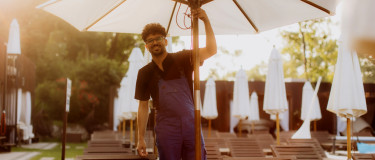 Resort maintenance worker fixes umbrella near pool | CMMS