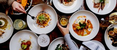 Plates of restaurant food with hands and arms | Maintenance
