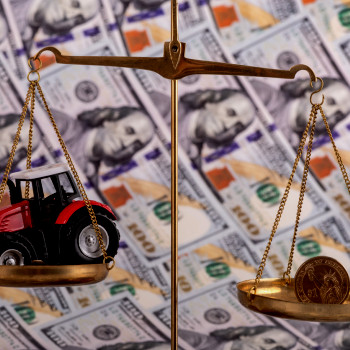 Scales with money on one side and a tractor on the other | CMMS