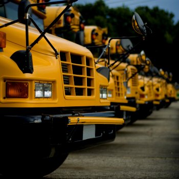 Fleet of yellow school busses in maintenance yard | CMMS
