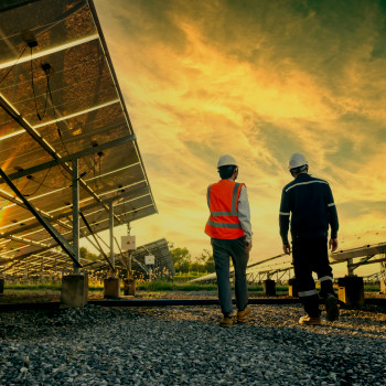 CMMS | solar farm maintenance technicians walking and observing solar panels