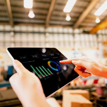 Technician using a tablet with maintenance graphs displayed | CMMS
