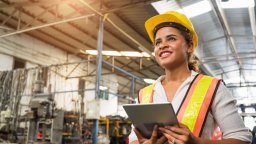 Female maintenance worker stands in front machines | CMMS